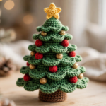 Crochet Christmas tree pattern – finished green tiered amigurumi tree with red and gold ornaments and yellow star topper